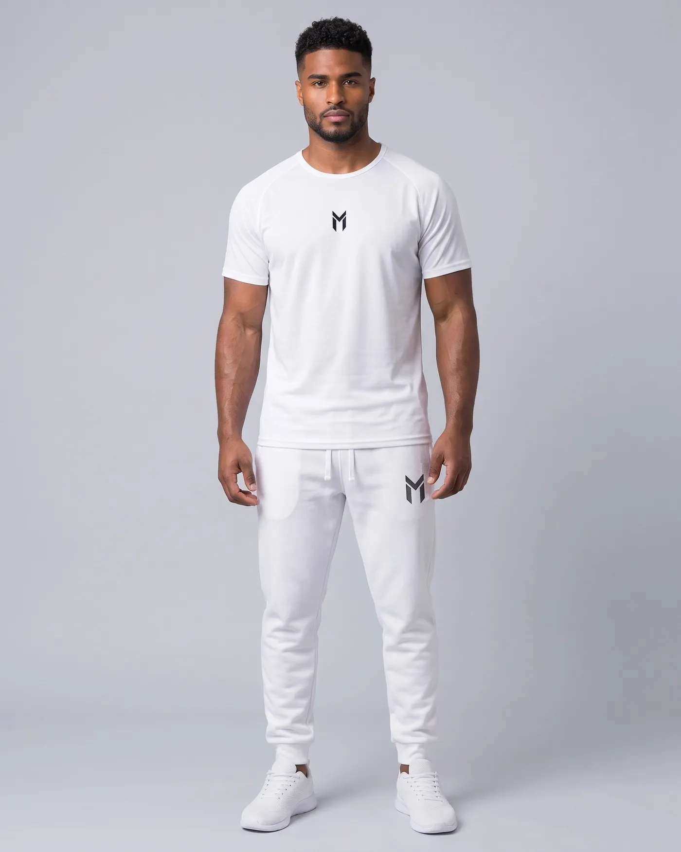 Person in weissem Jersey und weissen Fleece Joggers vor hellgrauem Grund