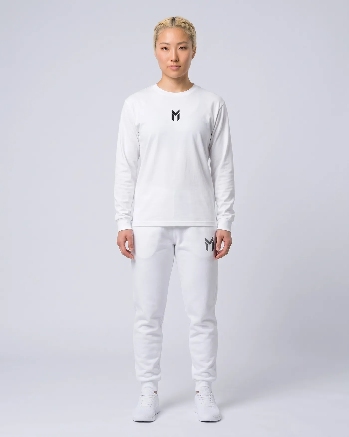 Person in weissem Heavyweight Long Sleeve und weissen Fleece Joggers vor hellgrauem Grund
